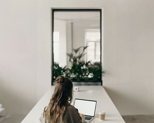 A woman sitting at the table with her laptop