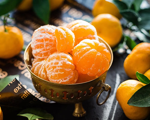 A bowl of oranges on top of a table.