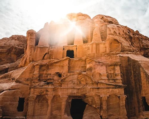 A large stone building with a sun shining through the window.