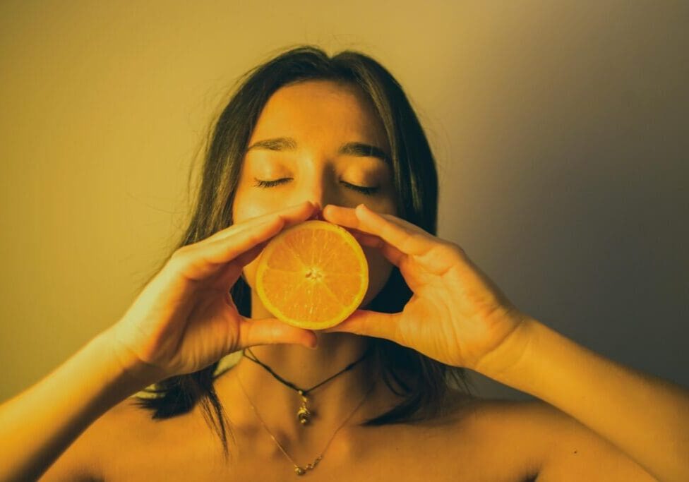 A woman holding an orange in her hands.